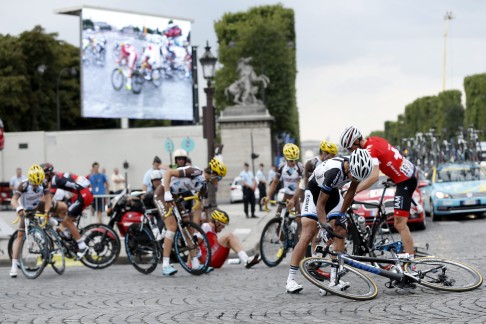 Ji Cheng (right) prepares to remount after a group crash on the final stage. Photo: EPA
