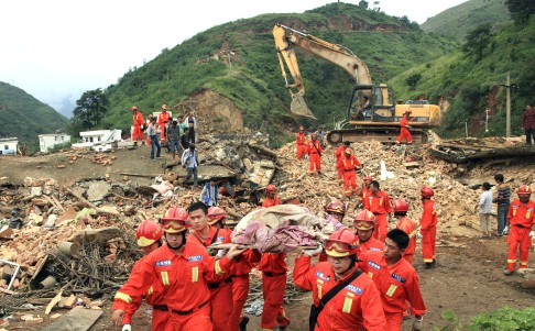 Rescue workers remove a dead body from the remains of a collapsed building at the epicenter of Sunday's earthquake. Photo: AP
