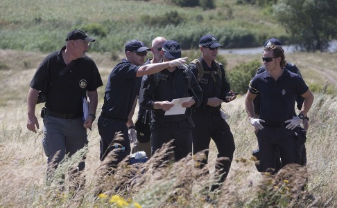Australian investigators examine the crash site of Malaysia Airlines flight MH17 plane crash in eastern Ukraine last week. Photo: AP