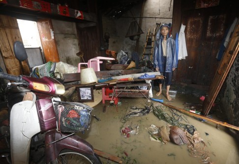 A farmer considers his options in his flooded home. Photo: EPA