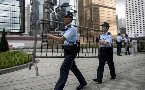 Police officers carry barriers outside Hong Kong government offices as they prepare for a protest by democracy activists on August 31, 2014. Photo: AFP