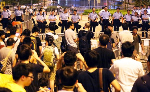 Protesters face a phalanx of officers in front of CY Leung's office on Tim Wa Avenue, Admiralty. Photo: Felix Wong