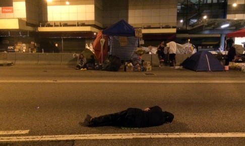 A protester rests with nothing but the hard gravel as his bed for the night in Admiralty. Photo: Ernest Kao