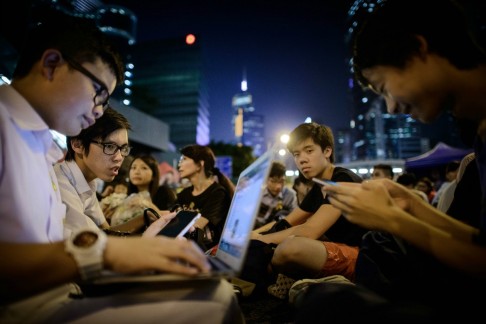 A young protester checks his laptop as crowds wait for speeches to begin at Friday's pro-democracy rally in Admiralty. Photo: AFP 
