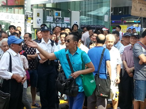 A man confronts protesters over pictures of several participants enjoying hot pot and table tennis in the Nathan Road camp. Photo: Thomas Chan