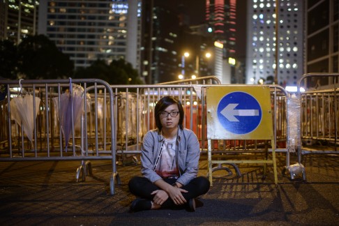Protester Daniel Cheng, 20, in front of a barricade that he helps to maintain on an occupied road in the Admiralty district. Photo: AFP