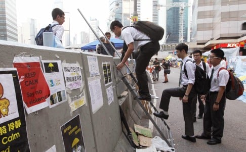 Students climb a ladder to reach a protest site in Admiralty. Photo: Edward Wong