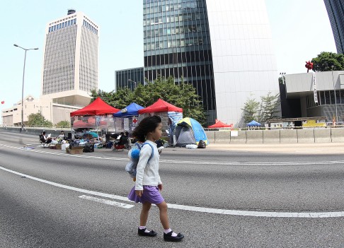 Day 10: A young girl takes a walk near Central, where vehicles have been off forced off the roads.