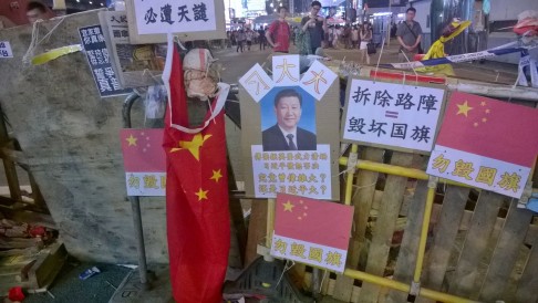 A road block in Mong Kok features the image of President Xi Jinping and a national flag. "If you tear down this roadblock, you will damage the national flag", a banner reads. Photo: Patrick Boehler