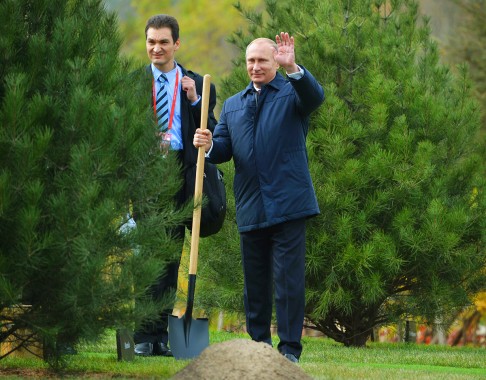 Russian President Vladimir Putin, right, waves with a shovel as he joins other world leaders for a tree planting ceremony at Friendship Lawn by Yanqi Lake for the Asia-Pacific Economic Cooperation Summit. Photo: AP