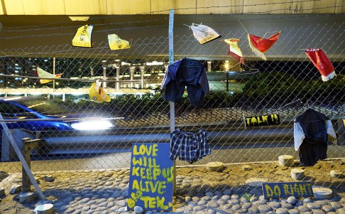 Some washed clothes hang on the fence under the flyover. Photo: Dickson Lee