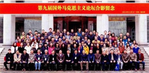 Yi (9th from left, front) at the centre of over 100 participants in a group shot.