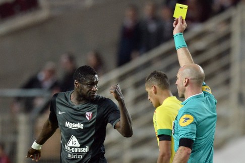 Metz midfielder Guiran N'Daw reacts as French referee Bartolomeu Varela shows him a yellow card. Photo: AFP