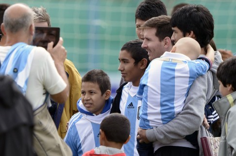 Argentina forward Lionel Messi (centre) poses for pictures with children at a training session in Ezeiza, Buenos Aires. Photo: AFP