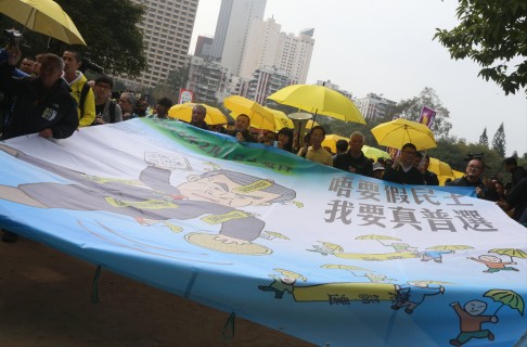 Protesters hold a head banner that appeals for "genuine universal suffrage" as they march from Victoria Park. Photo: Felix Wong