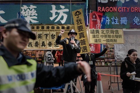 A policeman directs pedestrians as demonstrators shout slogans before the march. Photo: AFP