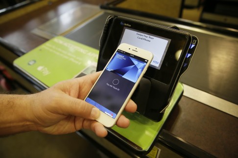 An Apple executive demonstrates the Apple Pay mobile payment system at a Whole Foods store in Cupertino, California in December 2014. Photo: AP