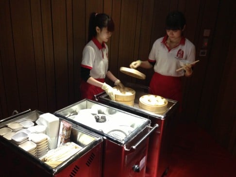  Waitresses offering dim sum to visitors form part of Rirkrit Tiravanija’s work "Untitled (freedom cannot be stimulated, Sundays are for dim sum)" at Chi Art Space. 