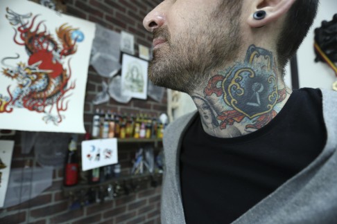 Guest tattooist at Star Crossed Tattoo Will Wallas shows off his neck art. 