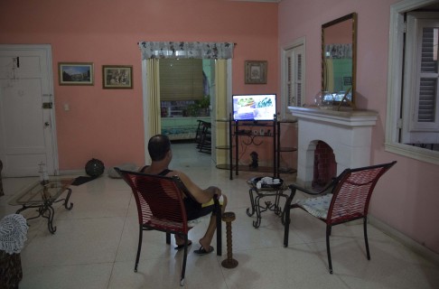 A homeowner sits in his living room at his home with rooms for rent in Havana. Photo: AP