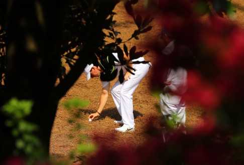 Seen through the foliage, Rory McIlroy has to take a drop off the #2 fairway. Photo: TNS