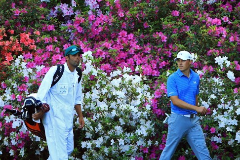 Spieth and his caddy walk past some typical Augusta colour. Photo: AFP