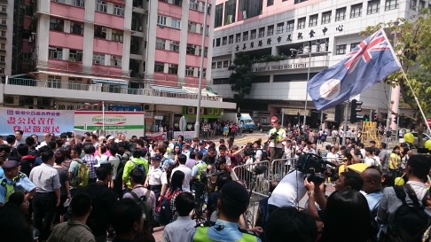 Protesters from rival political groups wait for the bus parade's arrival in Kennedy Town. Photo: Emily Tsang