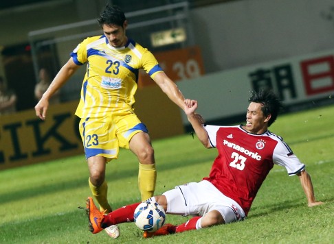 South China midfielder Che Runqiu slides in for the ball ahead of Global's Mark Hartmann. Photo: David Wong 