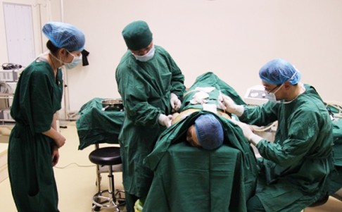 Surgeons perform fat removal surgery on a patient. 
