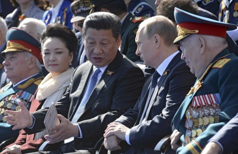 Xi Jinping, with first lady Peng Liyuan, speaks to Russian President Vladimir Putin during the Red Square victory parade. Photo: Reuters