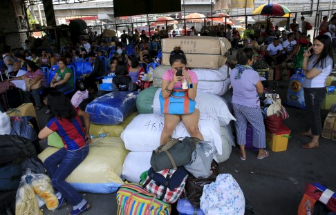 Stranded passengers guard their belongings while waiting at a bus terminal in Manila. Photo: Reuters