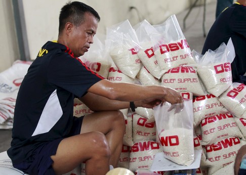 A member of the Philippine Armed Forces help volunteers repack food rations for victims of Typhoon Noul, in Pasay. Photo: Reuters