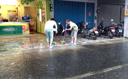 People clear the drainage during heavy rains caused by Typhoon Noul. Photo: CNA