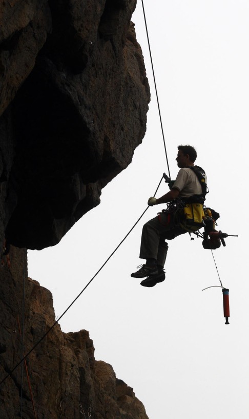 Francis Haden attaches new bolts onto the rock on Tung Lung Chau.