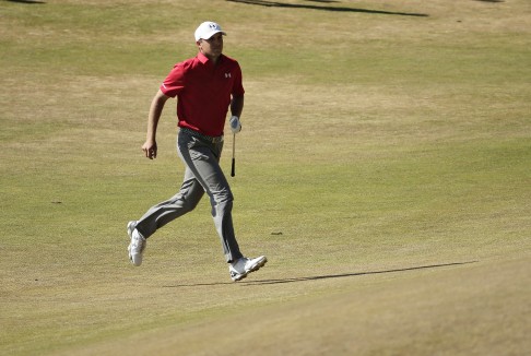 Jordan Spieth runs up to the eighth green to watch his ball roll out. Photo: AP