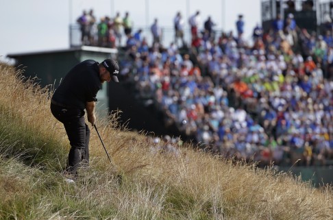 Shane Lowry, of Ireland, hits out of the tall fescue grass on the 16th hole. Photo: AP