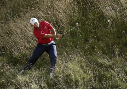 Patrick Reed hits out of the tall fescue grass on the 10th hole. Photo: AP