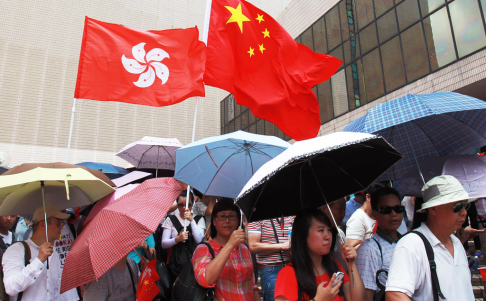 Away from the march, people attend the morning flag-raising ceremony in Tsim Sha Tsui. Photo: May Tse