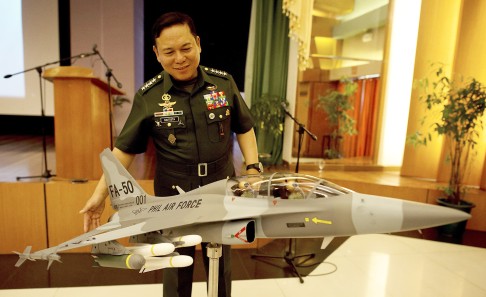 Armed Forces of the Philippines (AFP) chief of staff Emmanuel Bautista looks at a miniature model of a FA-50 fighter jet after signing a deal for the aircraft with Korea Aerospace Industries in 2014. Photo: AFP