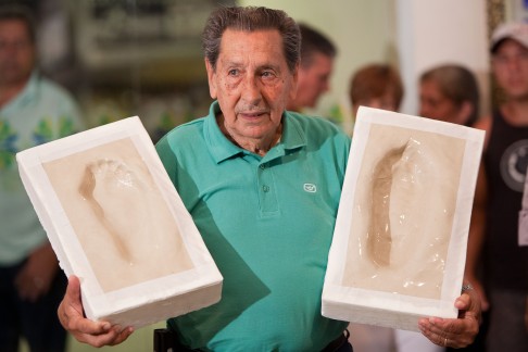 Ghiggia holds the prints of his feet that were placed on Brazil's Soccer Walk of Fame at the Maracana in 2009. Photo: AP