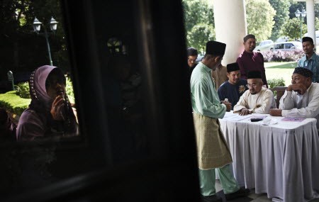 Husbands of the members of The Obedient Wife Club register themselves during a mass wedding ceremony in conjunction with the club's launch. Rahman Roslan 