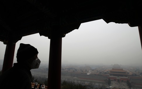 A man surveys the Forbidden City in Beijing yesterday as air quality in the capital descended to heavily polluted levels. Photo: Simon Song