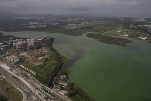 This July 27, 2015 aerial photo shows fluorescent green waters in the Marapendi Lagoon, in Rio de Janeiro, Brazil. The lagoons that hug the Olympic Park and which the government’s own data shows are among the most polluted waters in Rio were to be dredged, but the project got hung up in bureaucratic hurdles and has yet to start. (AP Photo/Leo Correa)