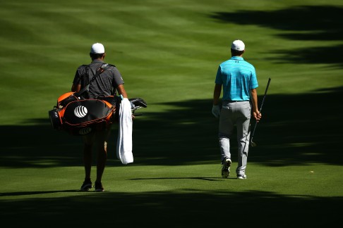 Cadday Michael Greller walks with Jordan Spieth down a fairway during a practice round at Firestone Country Club in Akron, Ohio.