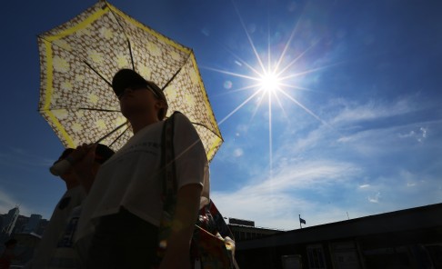 A man walks along the Tsim Sha Tsui public pier during sunset. The Hong Kong Observatory posted a warning for very hot weather today. Photo: Sam Tsang