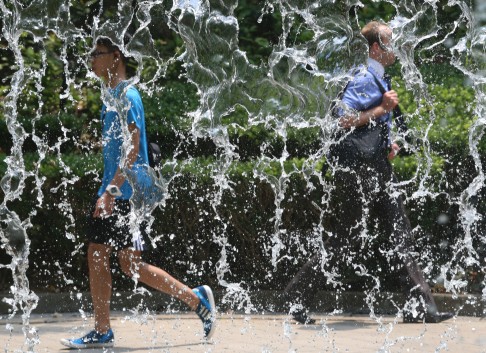 A fountain at Hong Kong Park helps people beat the heat as the mercury soars to its highest level at this time of year in over a century. Photo: David Wong