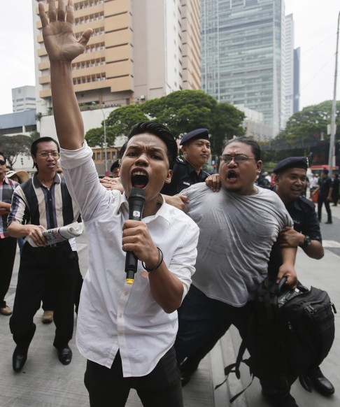 A supporter #TangkapNajib (Arrest Najib) is arrested by the Royal Malaysian Police during a protest in Kuala Lumpur, on August 1. Najib has come under increasing pressure to resign since the 1MDB scandal broke. Photo: EPA