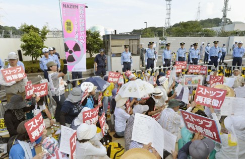 Protestors stage a sit-in in front of the Sendai nuclear plant. Photo: Kyodo
