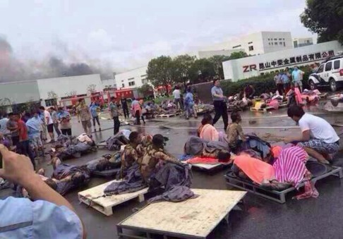 Rescuers help the victims of an explosion at the gate of a factory in Kunshan, Jiangsu province. Photo: Reuters