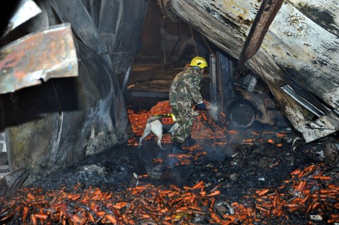 A rescuer works at the accident site after a carrot packaging workshop of Longyuan Food Company caught fire. Photo: Xinhua